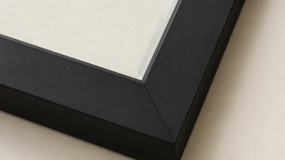 A close view of the corner of a plain matt black frame.
